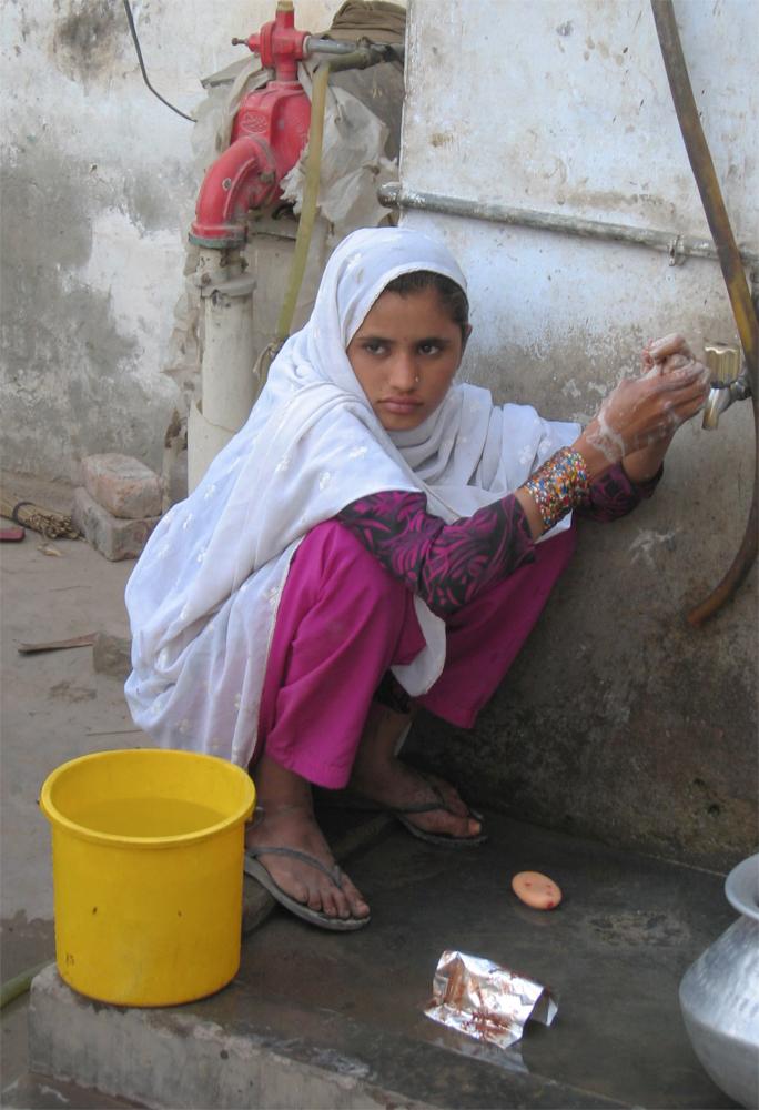 Una-chica-recoge-agua-en-el-taller-de-Munir